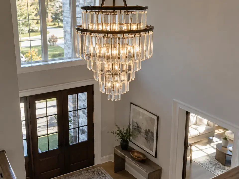 Chandelier viewed from the upper landing of a tall foyer.